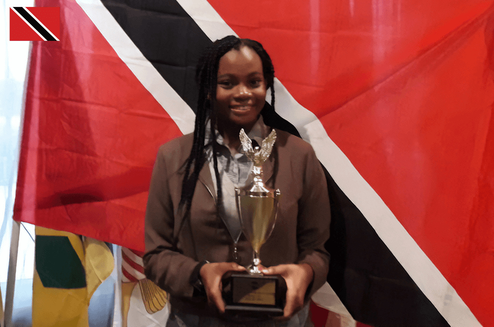 Woman holding trophy posing in front of flag