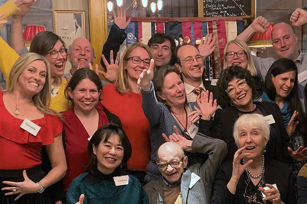 Group of people smiling and celebrating with hands up