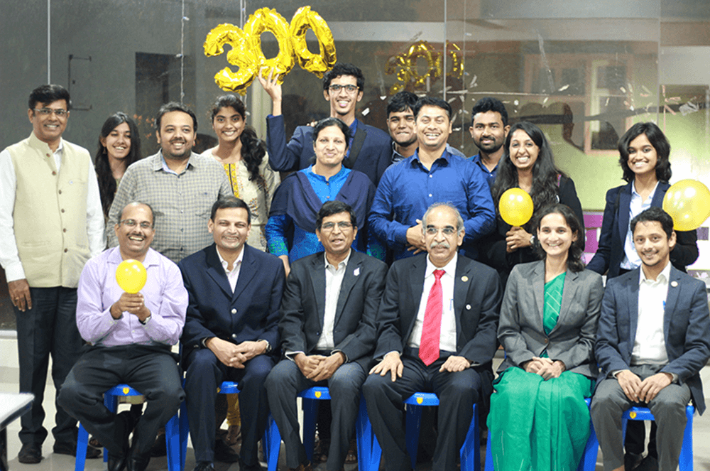 Group of people seating and standing holding yellow balloons