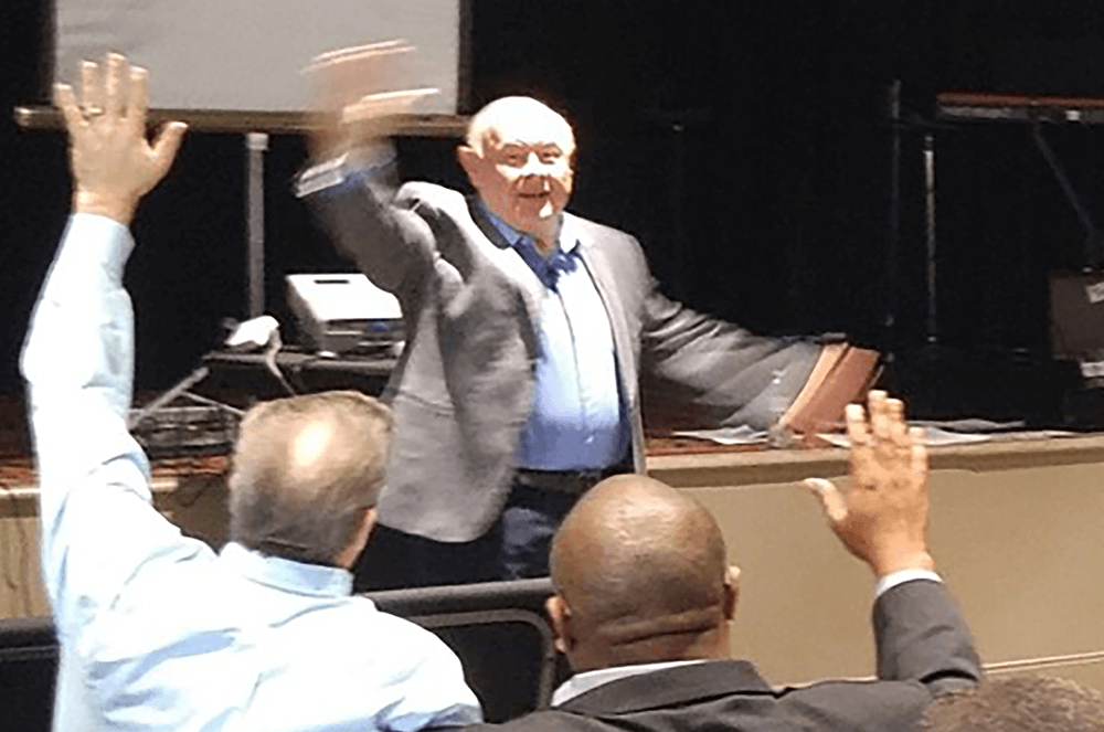 Man waving hands speaking to audience